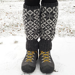 produktbild: Två ben som står ute i snön och har stickade benvärmare på sig