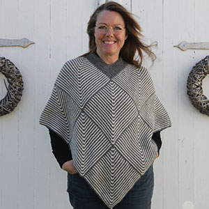 Produktbild: En kvinna som har på sig en grå, stickad poncho med rutiga mönster