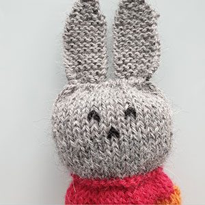 Produktbild: Överkroppen på en stickad liten kanin till barn.